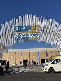 A large arch made of small metallic pipes with the words "COP27  Egypt 2022" marking the entrance to the COP27 conference.
