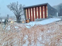 An interior lit building in the snow. 
