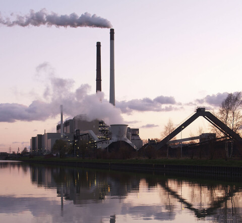 a coal-fired power plant reflected in water