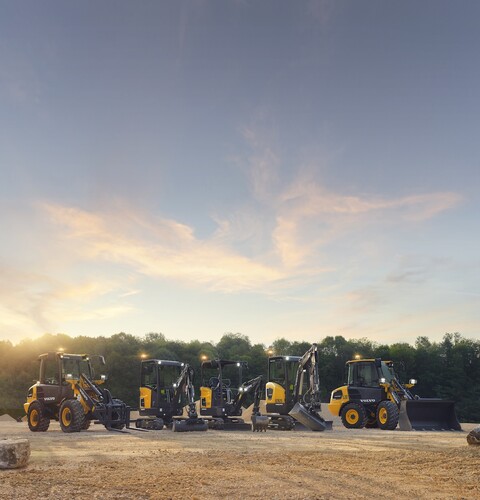 A line of yellow construction equipment, including front end loaders and others.