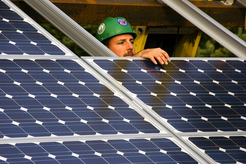  a worker installing solar panels